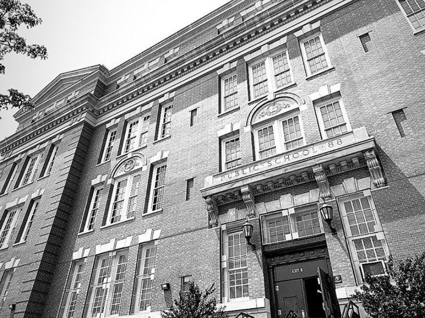 Black and white photo of the PS 88Q building on Catalpa Avenue, with PUBLIC SCHOOL 88 carved above the entrance
